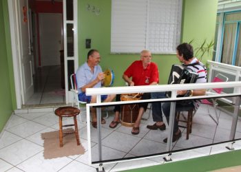 Trio transforma varanda de casa em palco e promove show na rua Independência